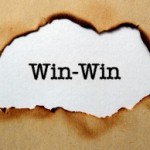 the words Win-Win appearing through a burned out hole in brown paper.