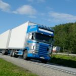 blue cab delivery truck driving on highway facing you. Photo credit GraphicStock