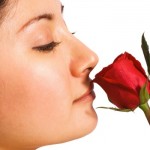 A girl smelling a red rose